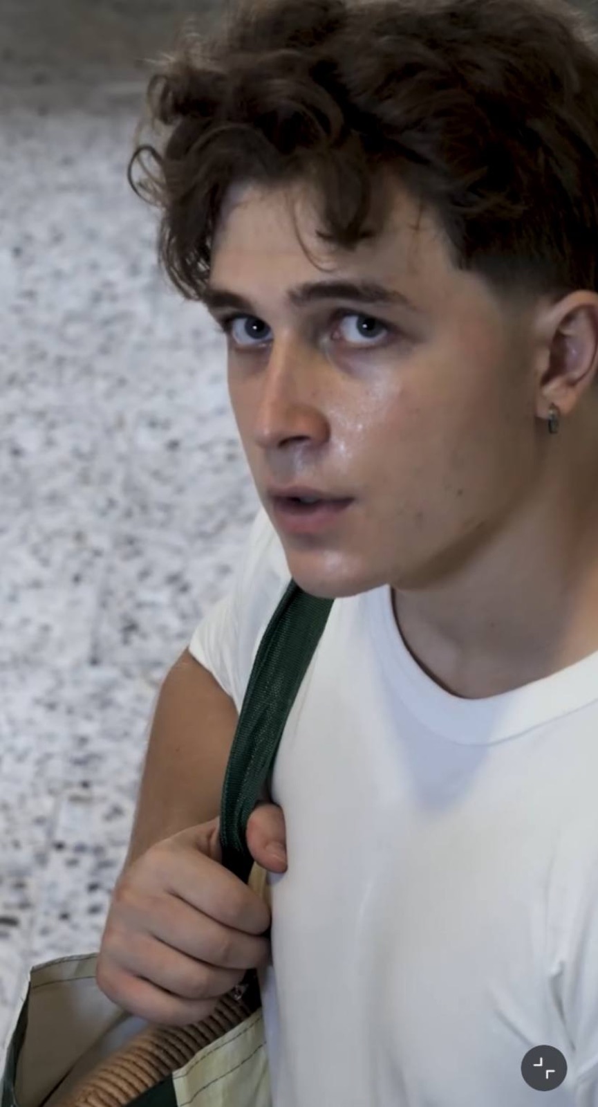 Close-up with a bag strap over a white T-shirt