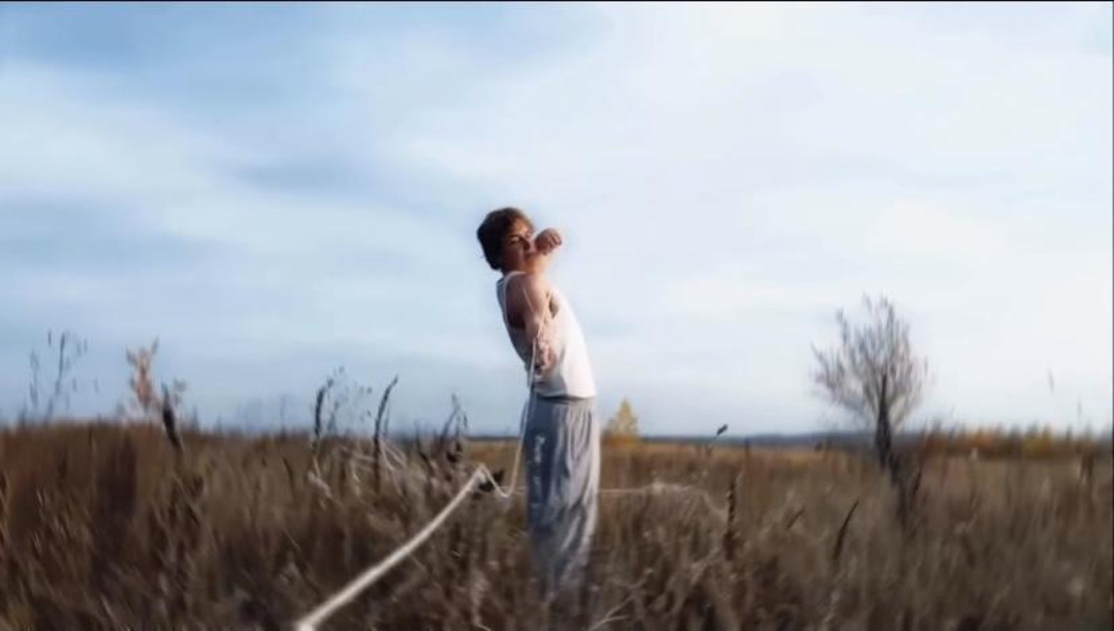 Arching back in a dry field under an open sky
