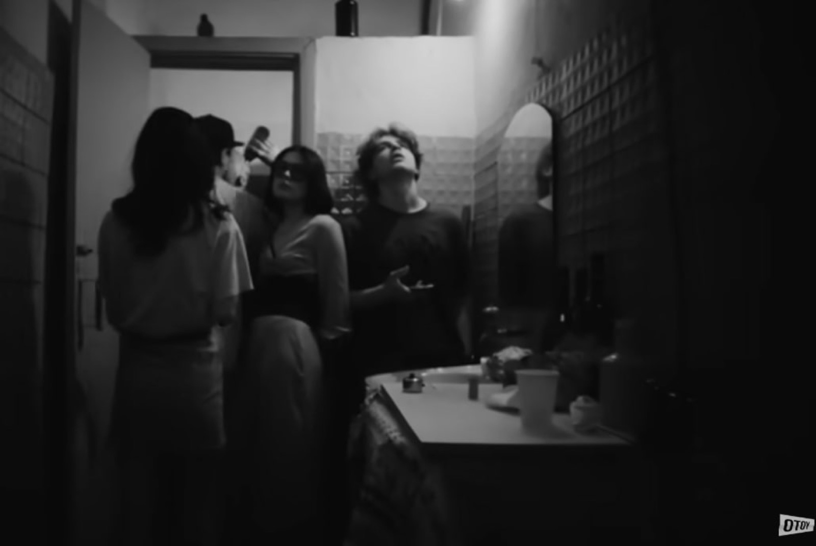 Black and white music video still, a group looking up