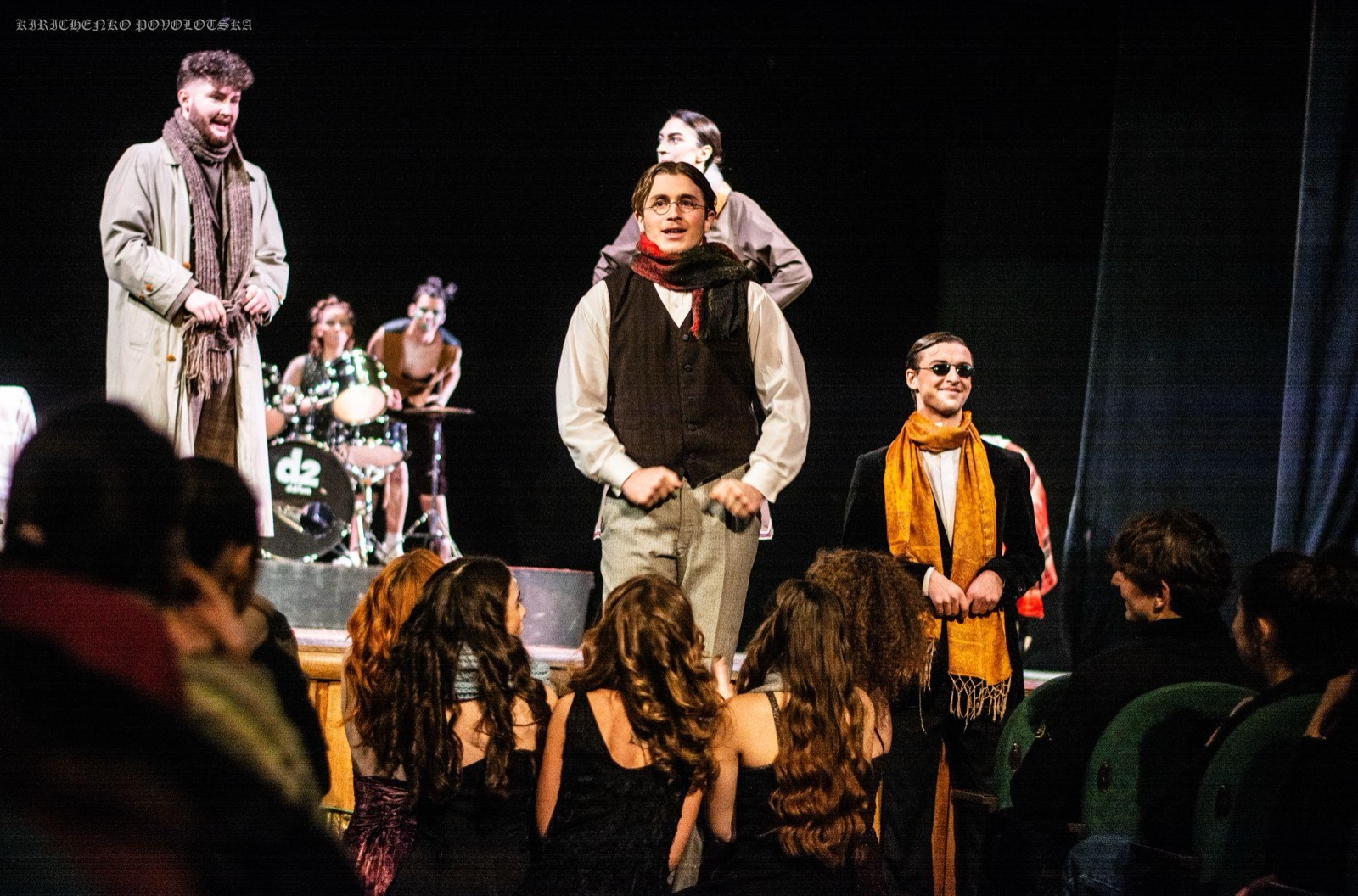 Costumed cast standing among the audience