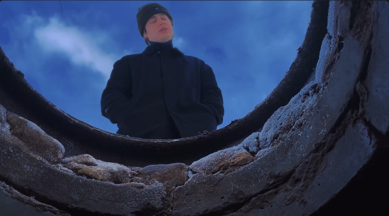 Low angle through a concrete pipe, music video still